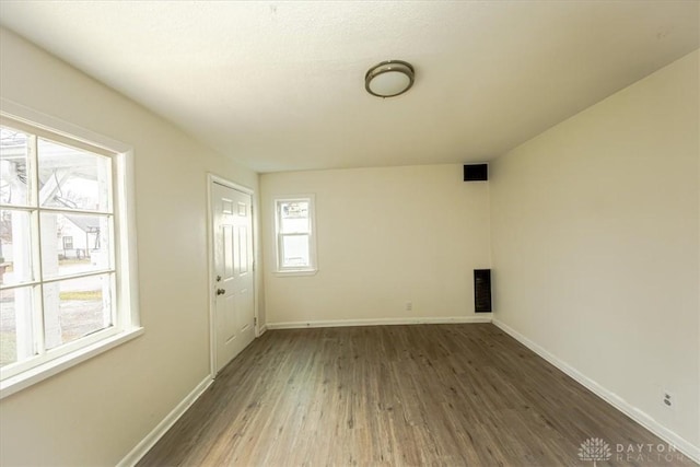 unfurnished room featuring a healthy amount of sunlight and dark hardwood / wood-style floors