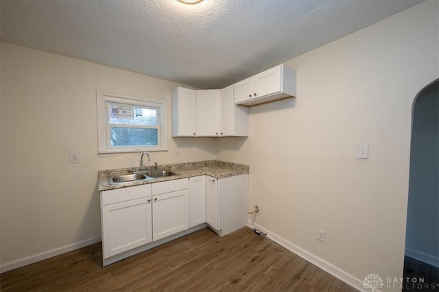 laundry room with sink, dark hardwood / wood-style floors, and a textured ceiling