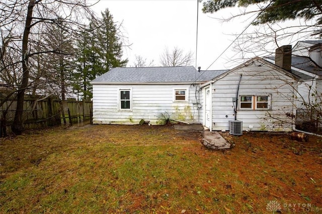 back of property featuring central AC and a lawn