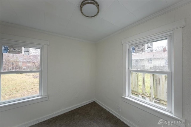 spare room featuring crown molding and dark carpet