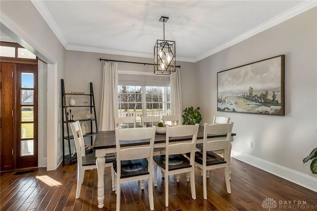 dining area featuring dark hardwood / wood-style flooring, ornamental molding, and a chandelier