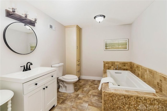 bathroom featuring vanity, toilet, and tiled tub