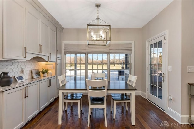 dining area featuring dark hardwood / wood-style floors, an inviting chandelier, and plenty of natural light