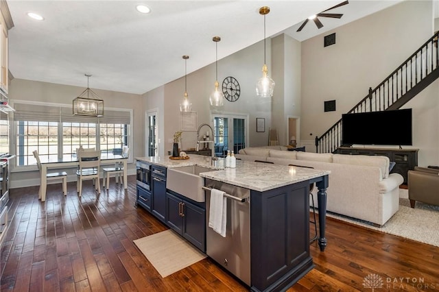 kitchen with a breakfast bar, pendant lighting, stainless steel dishwasher, and sink