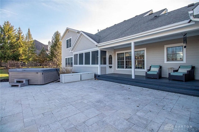 rear view of house with a patio area, a sunroom, a hot tub, and a deck