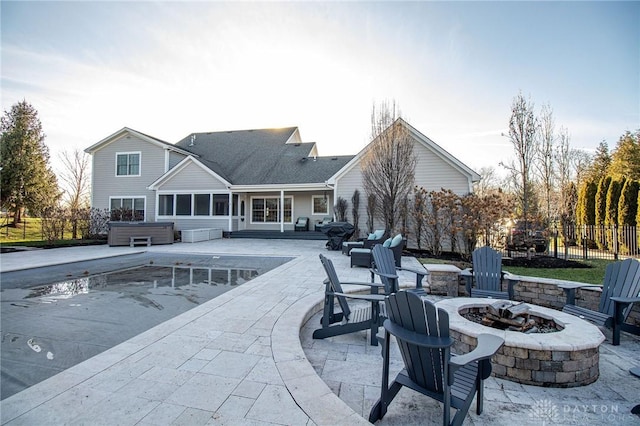 view of pool featuring a fire pit, a patio area, and a sunroom