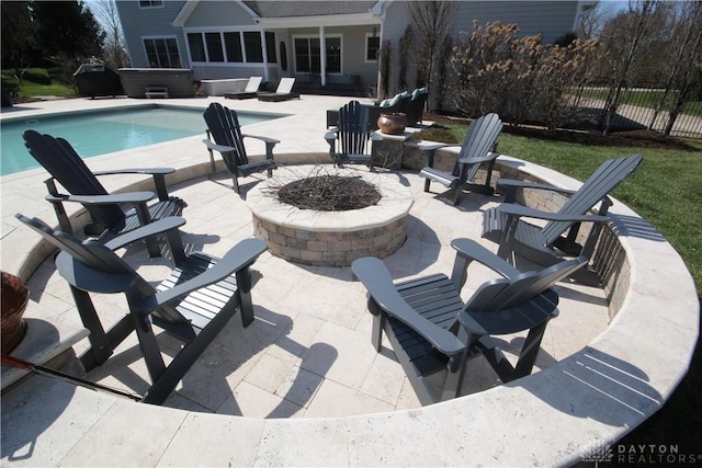 view of swimming pool with a fire pit, a sunroom, a patio area, and a hot tub