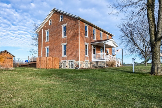 view of property exterior featuring covered porch and a lawn