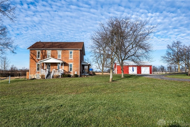 view of front of house with a front yard, an outdoor structure, and a garage