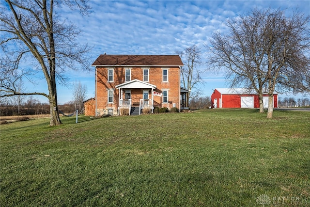 view of front of property with a garage, a front lawn, and an outdoor structure