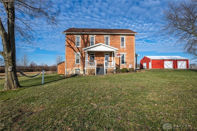 view of front of house with an outbuilding, a porch, and a front lawn