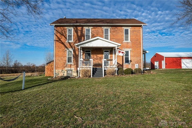 view of property featuring an outbuilding, covered porch, and a front yard