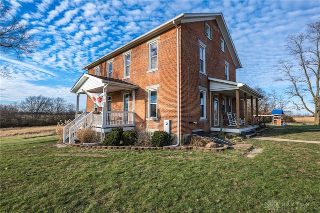 exterior space featuring covered porch, a playground, and a lawn