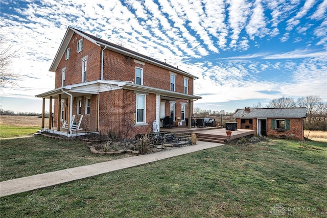 view of side of property featuring a yard, a wooden deck, an outbuilding, and a porch