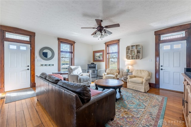 living room with a textured ceiling, light hardwood / wood-style flooring, and a wealth of natural light