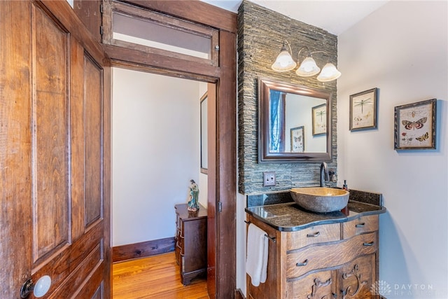 bathroom with decorative backsplash, wood-type flooring, and vanity