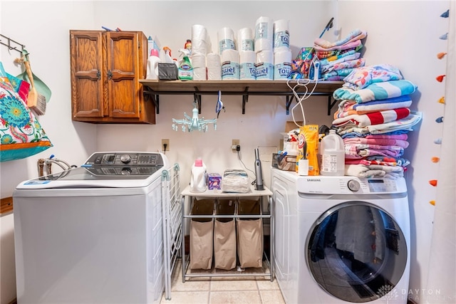 clothes washing area featuring cabinets, separate washer and dryer, and light tile patterned flooring