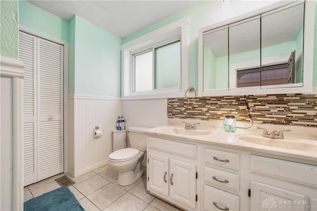 bathroom with toilet, vanity, and tile patterned floors