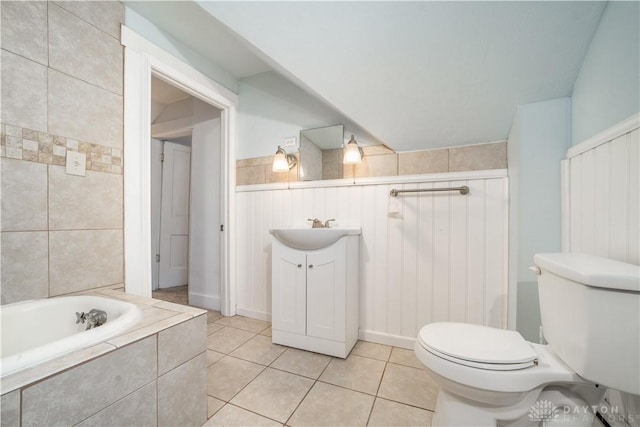 bathroom with tiled bath, tile patterned flooring, vanity, and toilet