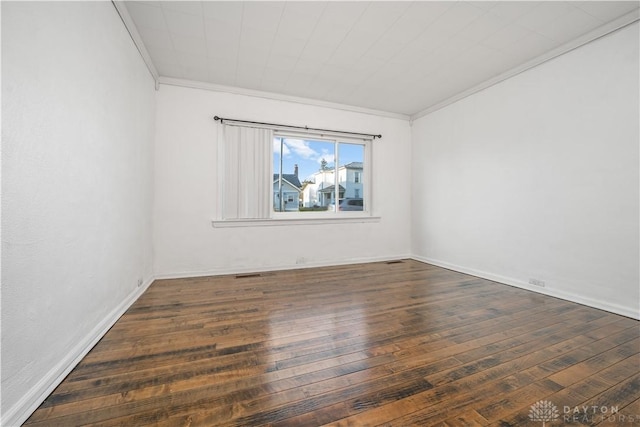 spare room featuring crown molding and dark hardwood / wood-style floors