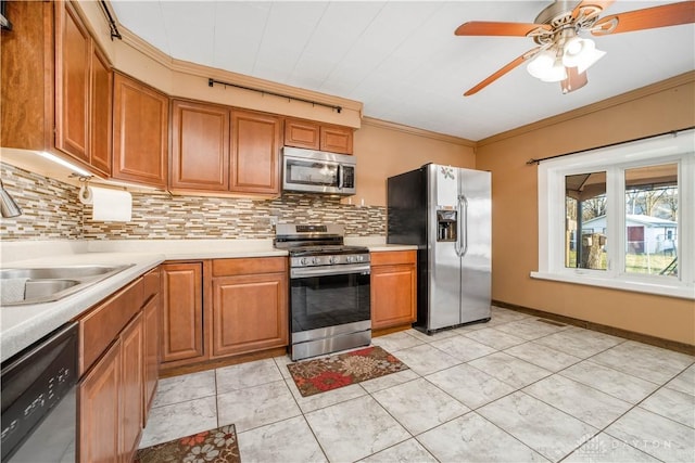 kitchen featuring decorative backsplash, stainless steel appliances, ceiling fan, crown molding, and light tile patterned floors