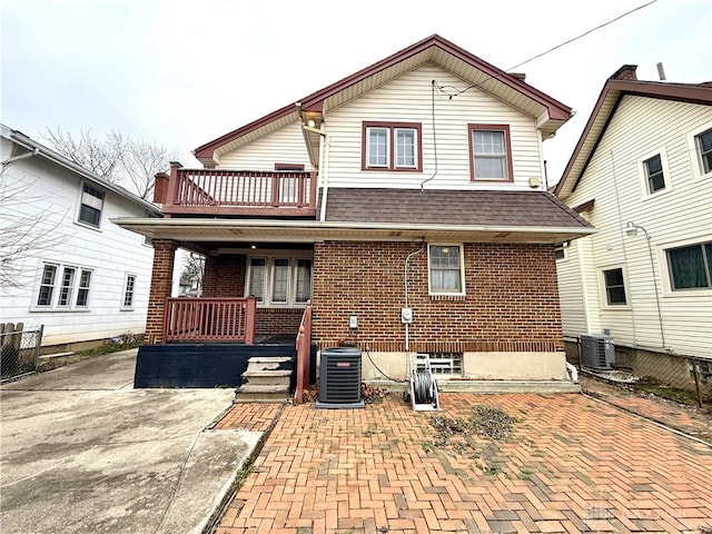 rear view of property with cooling unit and a balcony