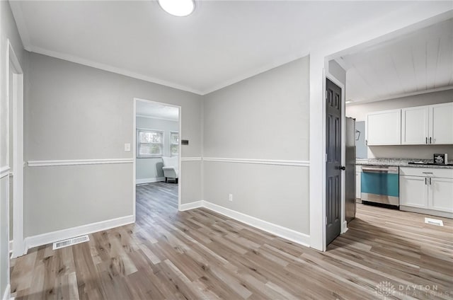 unfurnished dining area featuring ornamental molding and light wood-type flooring