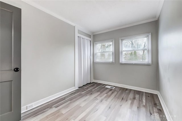 unfurnished bedroom with light wood-type flooring and crown molding