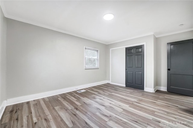 unfurnished bedroom featuring a closet, light hardwood / wood-style flooring, and ornamental molding