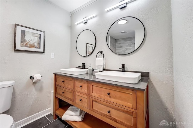 bathroom featuring tile patterned flooring, vanity, toilet, and crown molding