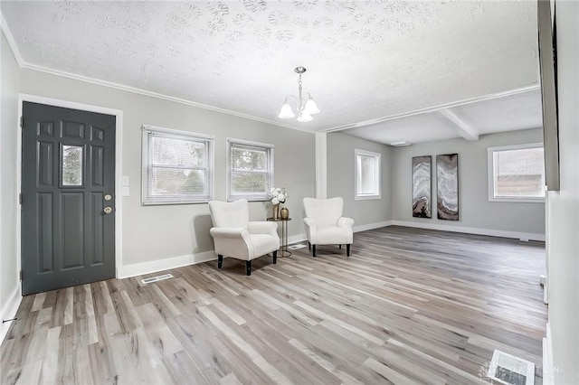 sitting room featuring beamed ceiling, a textured ceiling, light hardwood / wood-style flooring, and plenty of natural light