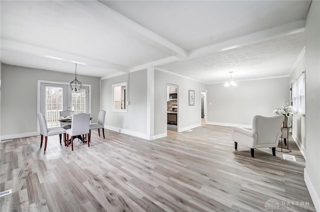 dining room featuring light hardwood / wood-style flooring, ornamental molding, and a notable chandelier