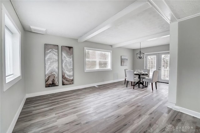 dining area with hardwood / wood-style floors, beamed ceiling, and a healthy amount of sunlight