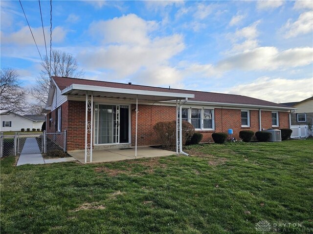 back of house featuring a lawn, a patio area, and central air condition unit