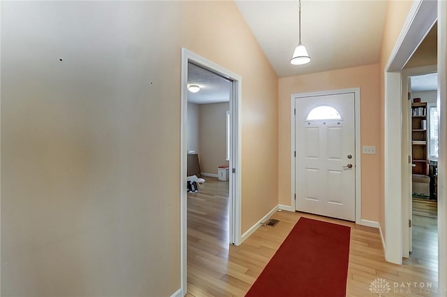 foyer entrance with lofted ceiling and light wood-type flooring