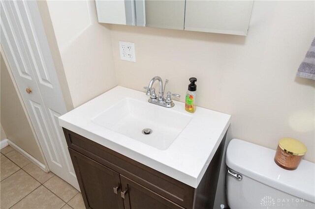 bathroom featuring tile patterned flooring, vanity, and toilet