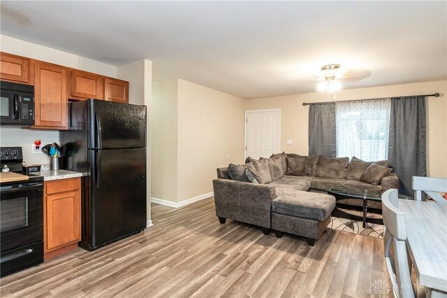 living room with ceiling fan and light hardwood / wood-style flooring