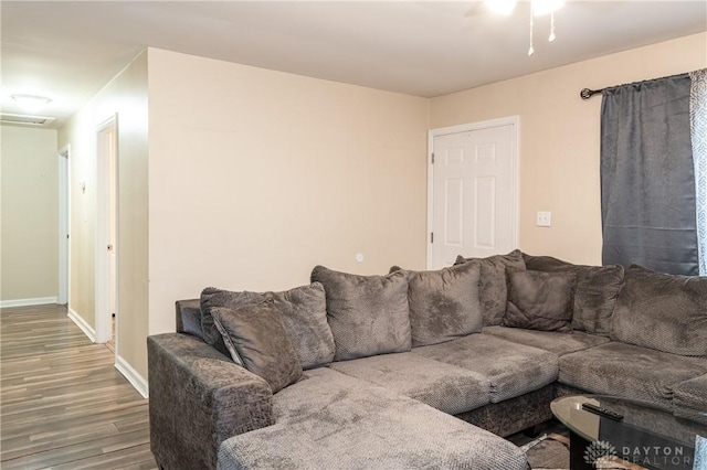 living room featuring wood finished floors, visible vents, and baseboards