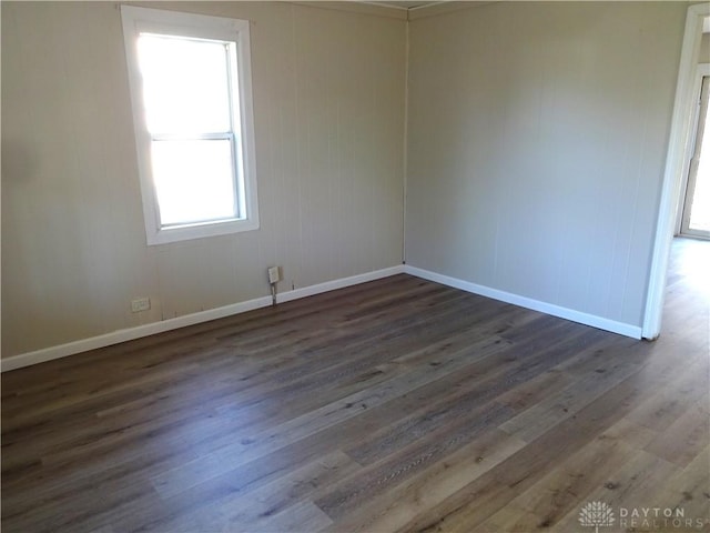 unfurnished room with dark hardwood / wood-style flooring