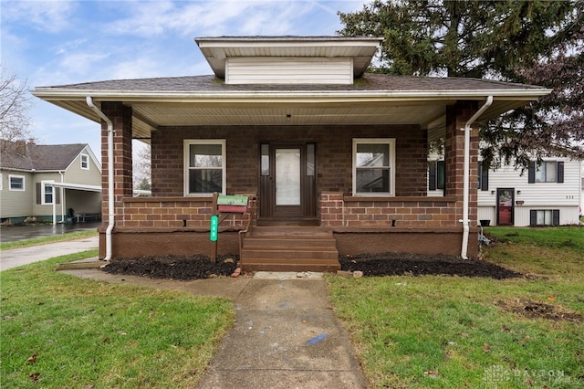 bungalow with a front yard and covered porch