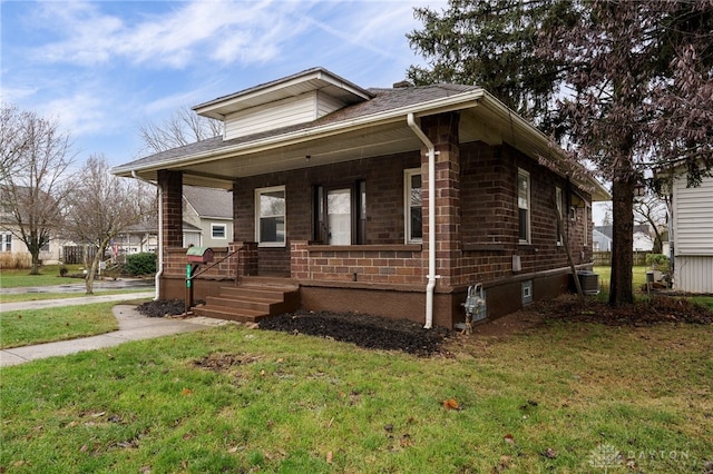 view of front of property featuring a front lawn, central AC unit, and covered porch