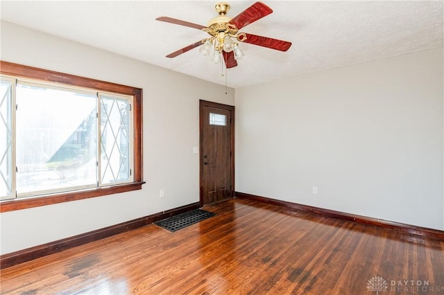 spare room featuring ceiling fan and dark wood-type flooring