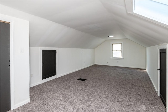 bonus room with carpet floors and vaulted ceiling