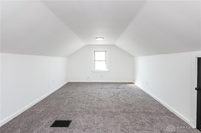 bonus room with carpet flooring and vaulted ceiling