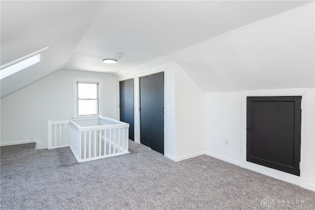 bonus room featuring carpet and vaulted ceiling with skylight