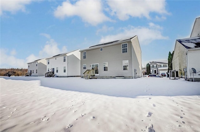 view of snow covered rear of property