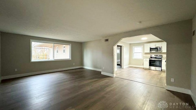 unfurnished living room featuring hardwood / wood-style floors and a healthy amount of sunlight