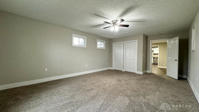 unfurnished bedroom with ceiling fan, carpet floors, and a textured ceiling