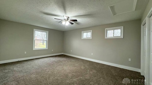 carpeted spare room with a textured ceiling, a wealth of natural light, and ceiling fan