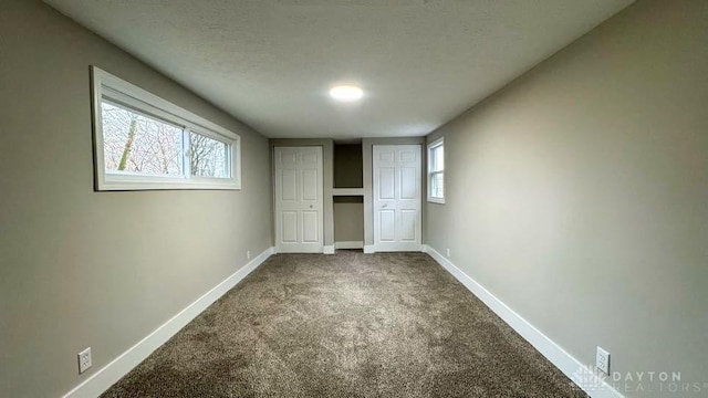 unfurnished bedroom featuring carpet flooring and multiple windows